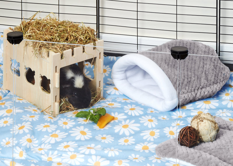 gray fleece sleep sack next to guinea pig hiding in wooden castle tunnel sitting on daisy print fleece liner in c and c cage