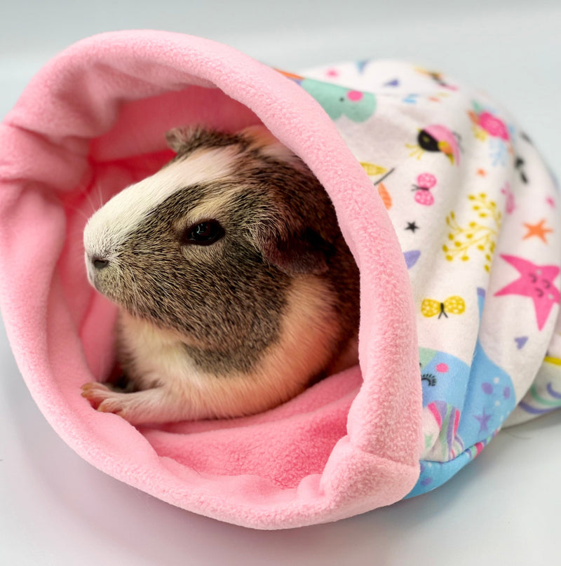 grey and white guinea pig in a pink fleece sleepbag with unicorn from kavee